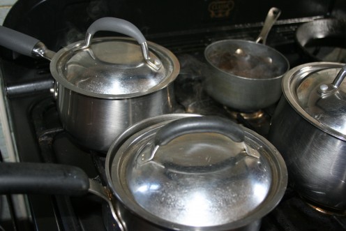 Saucepan replaced on heat after water has been drained, to allow potatoes to dry a little. Note that the saucepan lid is slightly open to let steam escape