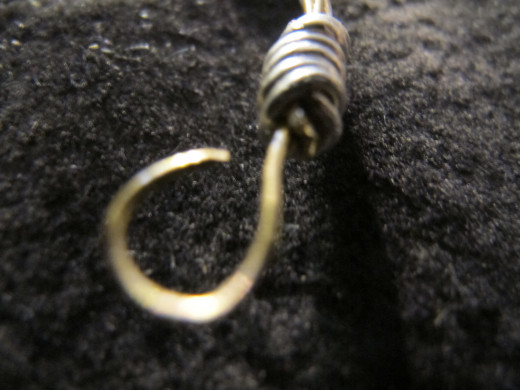 At the other end, form a hook (an open loop) that's perpendicular to the bracelet and the closed loop.