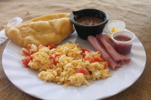 Belizean breakfast. Ham, scrambled eggs, beans and fry jacks with butter and jam on the side.