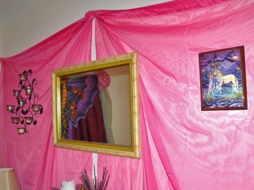 My bedroom has one pink wall.  I used a pair of old Georgette curtain panels and put them on the wall using nothing more than tacs.   Tip:  Do NOT use candles near the wall when using fabric.  