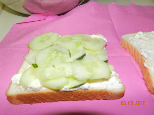 Top the cream cheese with cucumber slices.