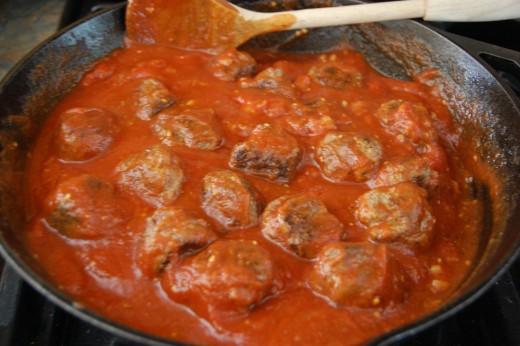 simmering the meatballs in the sauce