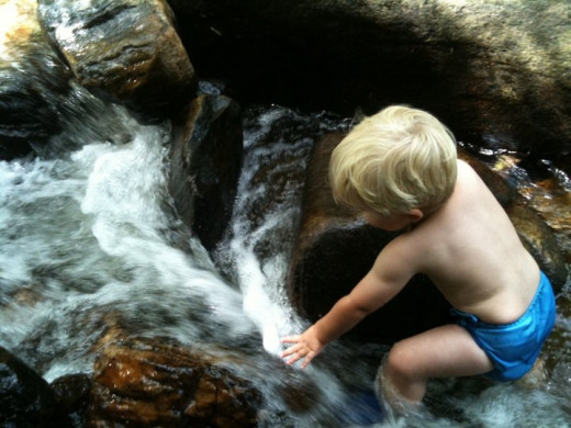 Playing in a stream using a diaper cover as a swim diaper.