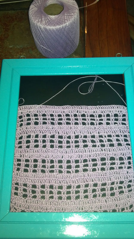 Material insert for frame: an open weave crochet mesh pattern.