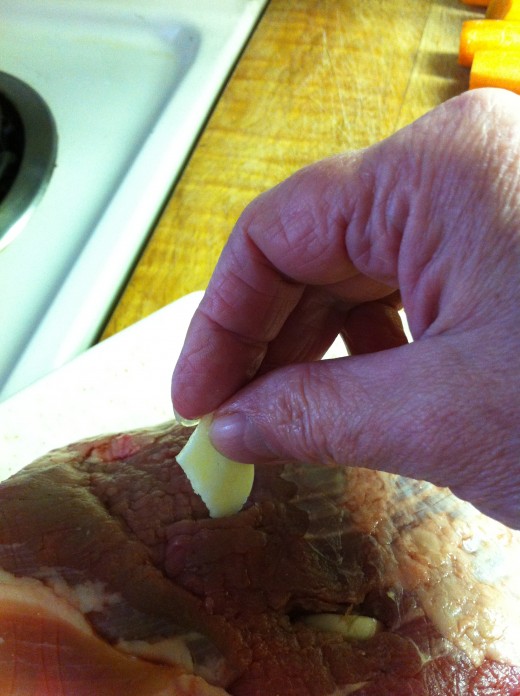 Insert garlic slices into the roast.