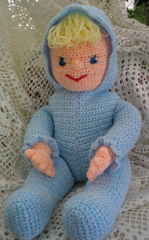 CROCHETED DOLL WEARING BLUE by Jprescott A crocheted doll toy with blonde hair wearing a blue suit with a hood.