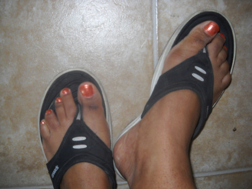Toe nails painted with bronze polish.