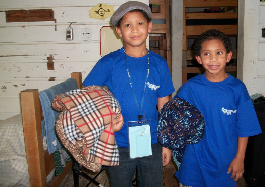 Campers settling into their cabin with blankets donated by Project Linus.