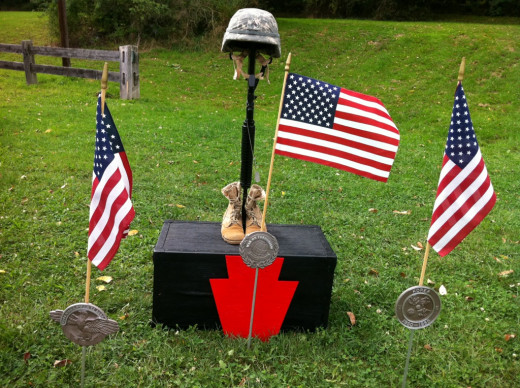 "Fallen Soldier Battle Cross" (Boots, Rifle, Helmet) set up in memory of Sgt. Jan Argonish.