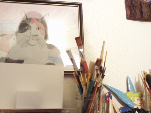Picture of my colored pencil cat drawing from 2007.  My paintbrushes are also in the picture.