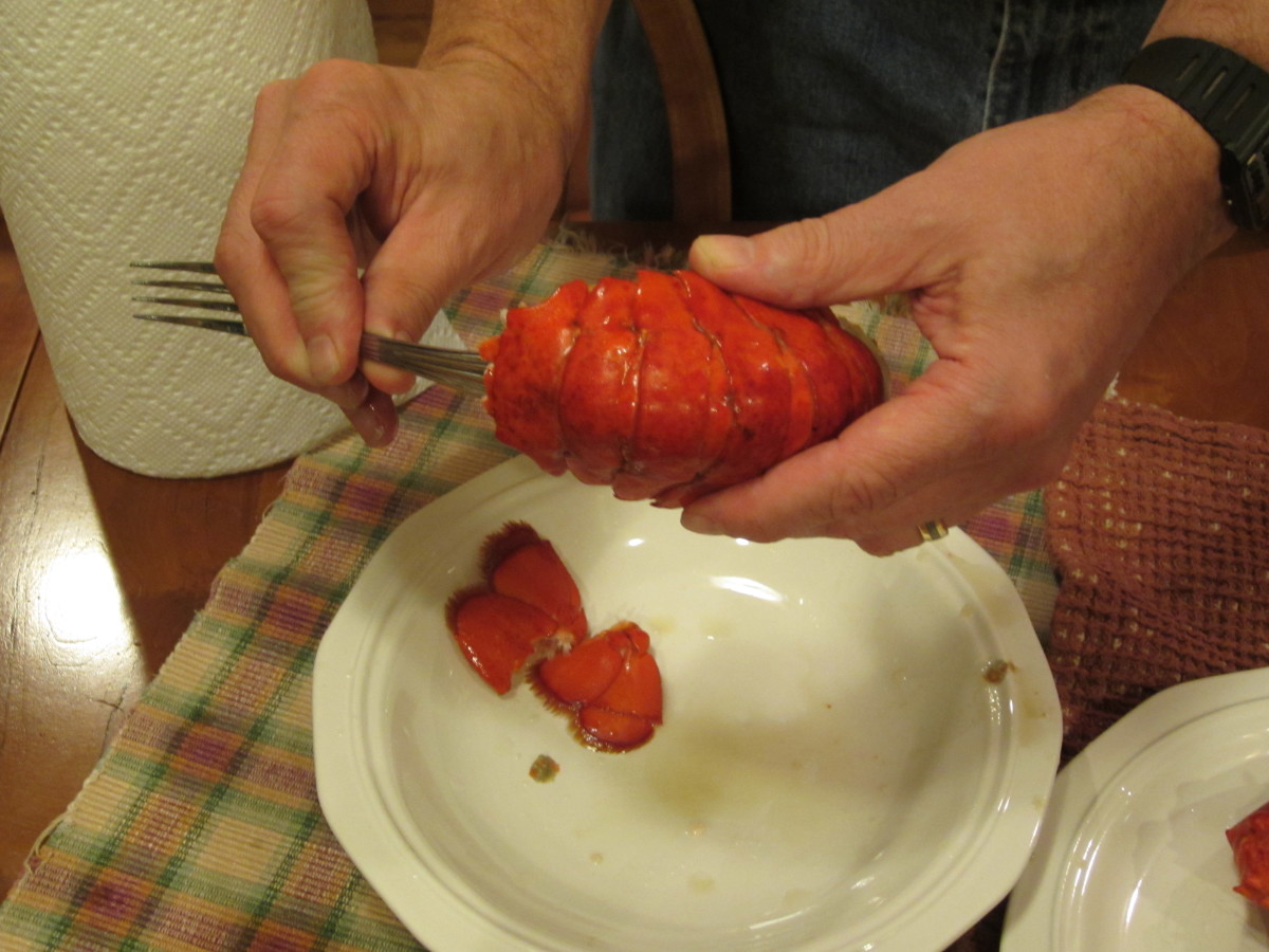 Inserting the handle of the fork into the shell of the tail to remove the meat.