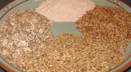 Photograph of 4 gluten sources. Top: High-gluten wheat flour. Right: European spelt. Bottom: Barley. Left: Rolled rye flakes.