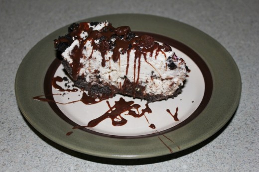 Ice cream cake with Oreo crust, topped with brownie bites and Oreo crumbs, and drizzled with hot fudge sauce.