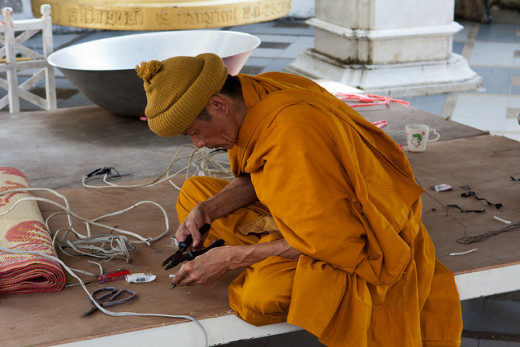 A Buddhist monk doing electrical work … mindfully.