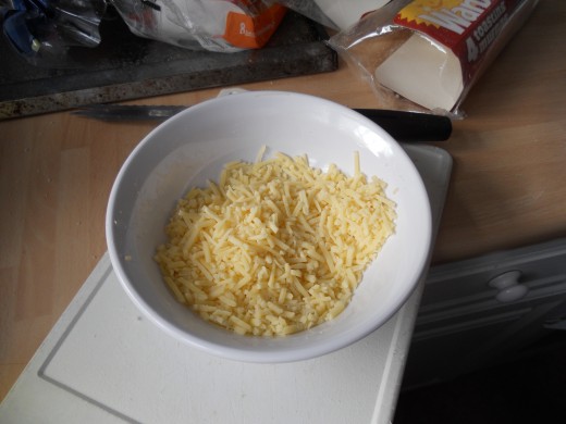 Whilst the muffins are toasting, grate some hard cheese into a bowl