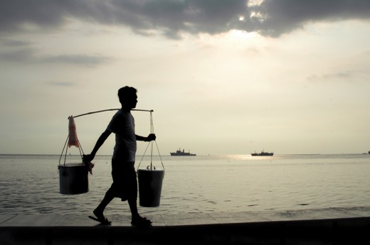 A taho vendor, starting early in the morning calling out "taho." he carries two buckets, one for the fine tofu and the other for sago pearls and brown sugar syrup.  He could be spotted selling taho throughout the day. 