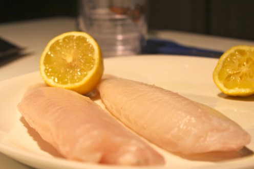 Squeezing lemon juice on fish filets enhances a fresh flavor.