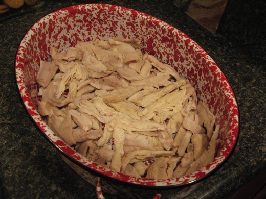 Tear cooked chicken into small pieces and place in pan or dish.