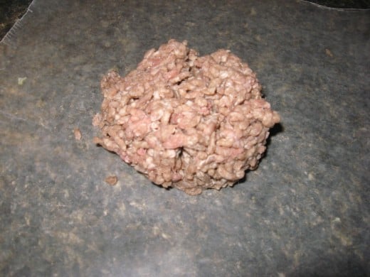 Measure the ground beef and turn it onto a sheet of waxed paper.