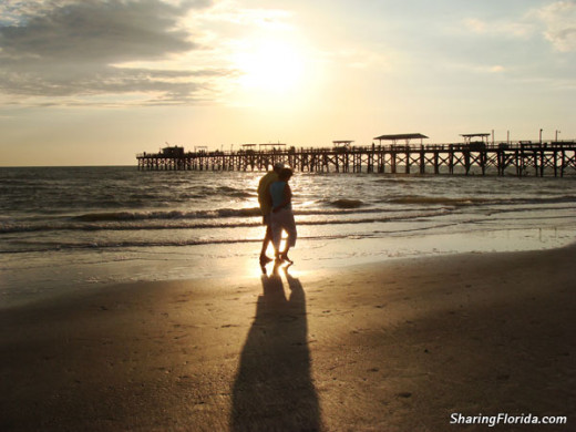 Couple walking beach at sunset