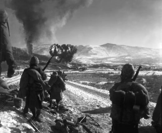 U.S. Marines move forward after close-air support flushes out the enemy from hillside trenches.