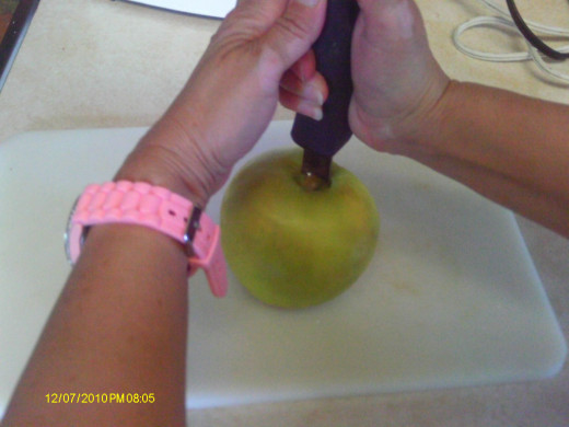 Plunging the apple corer into the apple