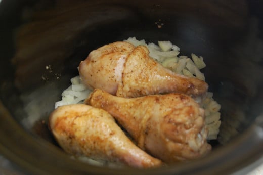 Place the browned legs in the slow cooker on the onions and garlic