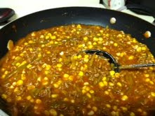 Browned ground beef, onions, corn, french style green beans, tomato soup, and seasonings mixed and simmering.