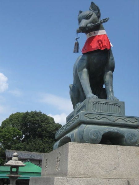 Fox statue with a key in its mouth at the Fushimi Inari-taisha main gates.