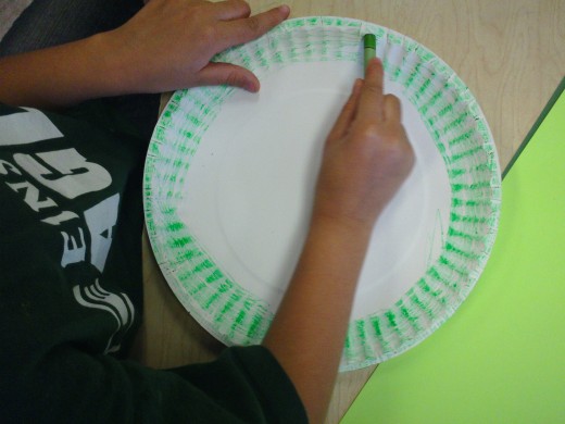 Coloring the outer circle of the plate.