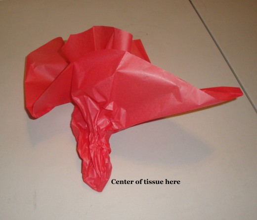 To gather tissue paper to cover a larger gift.  First put gift into bag, then gather a few pieces of tissue paper as shown, then fill in the open spots in the bag.