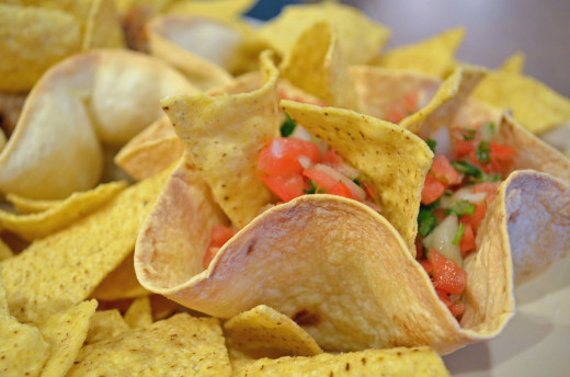 Place several tortilla bowls with dips on a platter and surround with dipping chips.