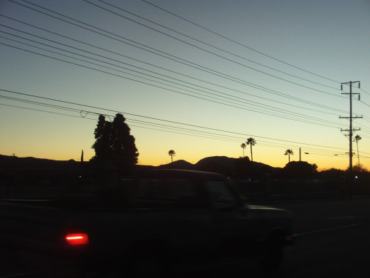 Silhouettes of hills and palm trees.