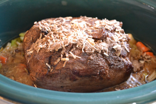 Place the browned roast on top of the vegetables and sprinkle it with salt, pepper, garlic and dry onion soup mix.