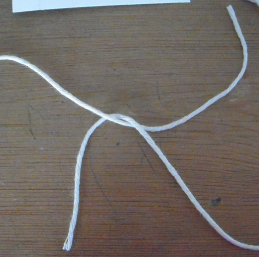 Loop the right-hand strand over the left strand. Pull snug to the previous.