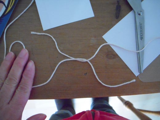 Loop the left-hand strand over the right strand, like tying a pair of shoelaces, and pull snug to the tape .