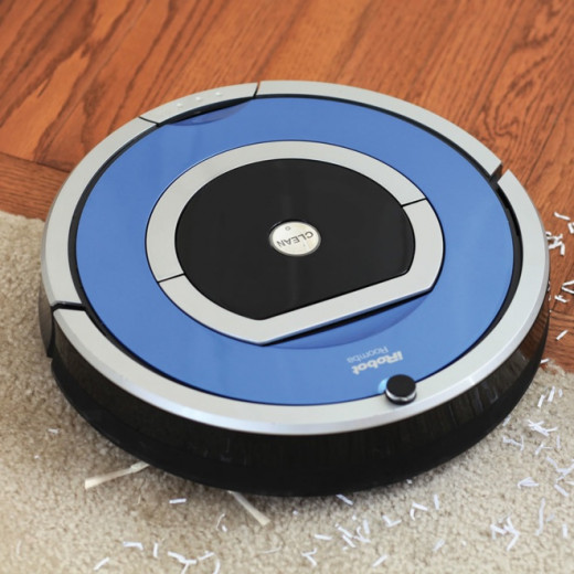 A Roomba iRobot automatic vacuum that cleans all surfaces from carpet to laminate to tile by gliding across surfaces picking up dirt along the way. 