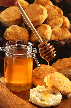 .A jar of honey with honey dripper.