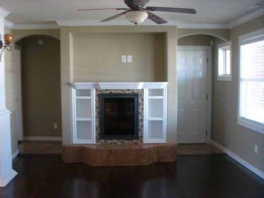 This added fireplace with modern glass tilework has shelving built in on the sides and a space for a flat screen TV above.