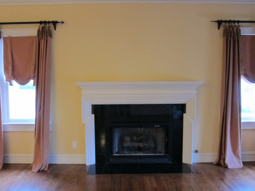 BEFORE Simple fireplace mantle with black marble surround and white wood mantle.
