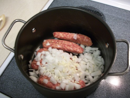 Step 3.  Remove casings from sausage. Dice the onion, mince the garlic, sliver the carrots. Cook sausage, onion, garlic, and slivered carrots over medium heat until sausage is browned. Stir to crumble.