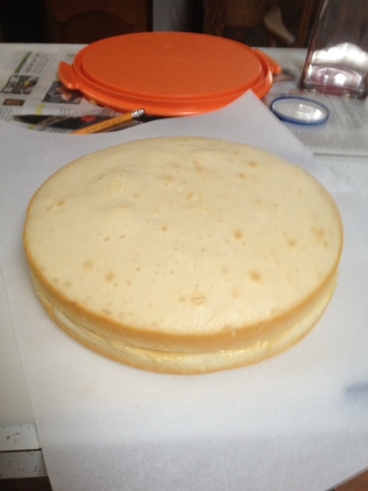 The bottom layer topped with filling and the second layer