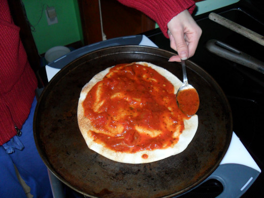 Spread the pizza sauce on with the back of a spoon