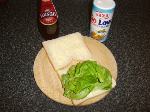 Lettuce is laid on bread and seasoned with salt and malt vinegar