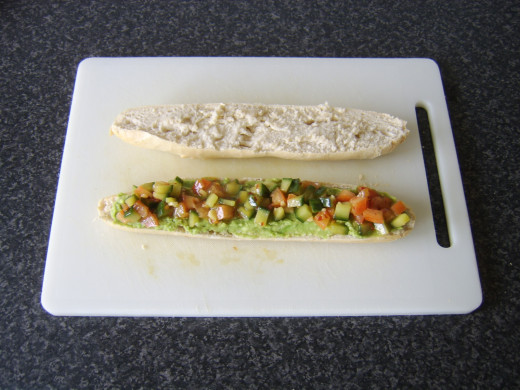 Ccucumber salsa is spooned on to the mashed avocado