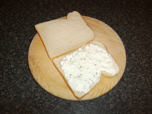 Cottage cheese is spread on one slice of bread