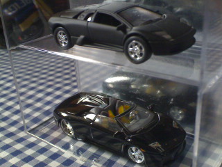 The one of the top is Bruce Wayne's Lambo (The Dark Knight) that saved the life of the snitch while the one on the bottom appeared on the first film of Christian Bale as Batman