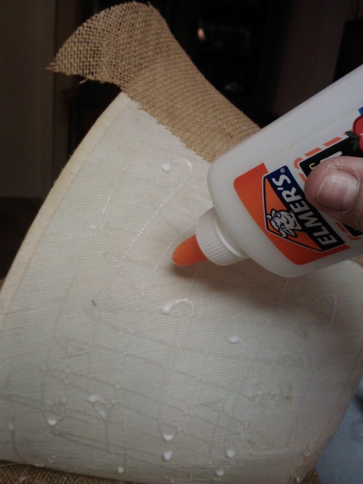 A little Elmer's glue holds fabric in place while attaching it to the frame and adding trim.