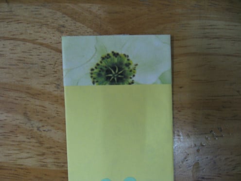 apply glue at the back of the wrapper and paste it around the top of the bookmark