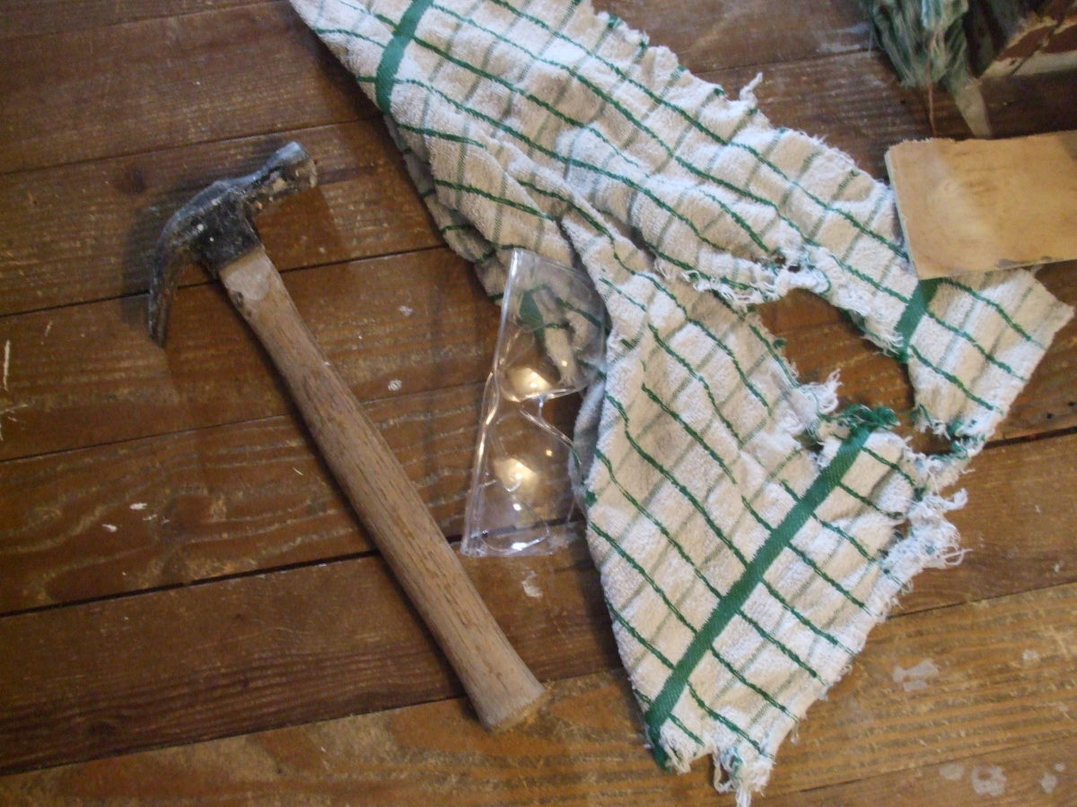 A hammer, safety eye goggles, and an old towel.